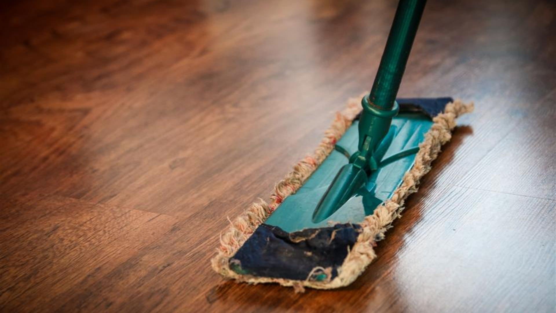 Mopping a hardwood floor during a professional home cleaning